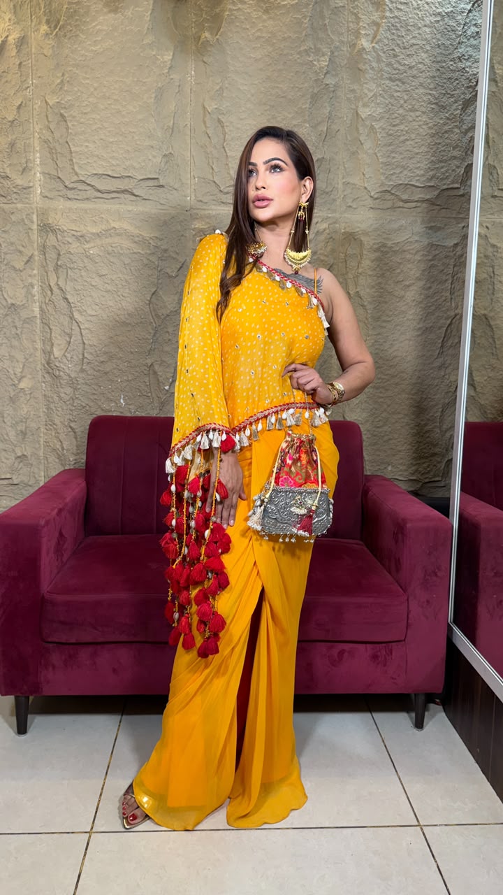 Women's mustard yellow georgette ready-to-wear saree with mirror work embellished one-shoulder cape and tassel detailing.
